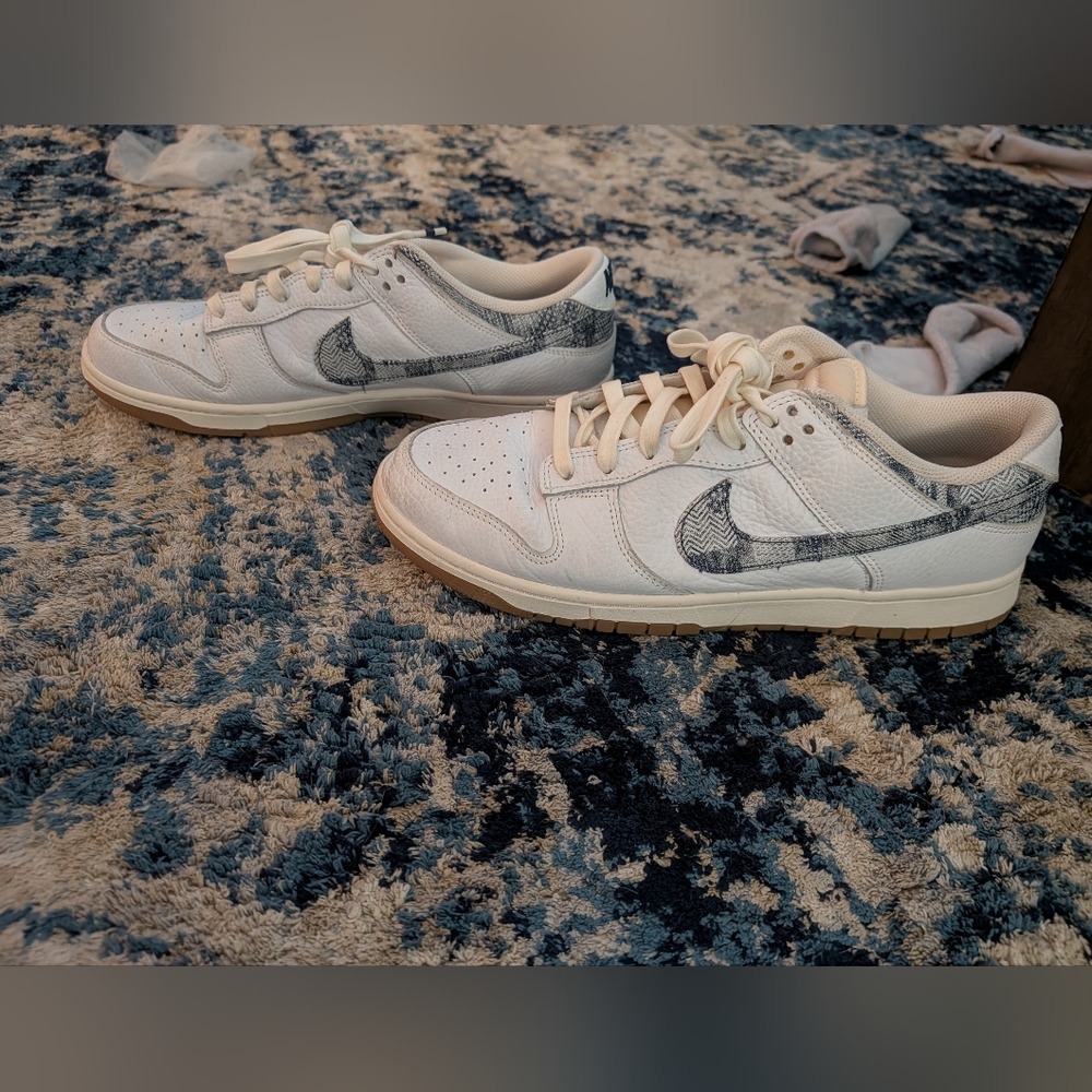 This is a Nike Dunk Low 'New AmericWhite and Gray Sneakers with Patterned Swoosh